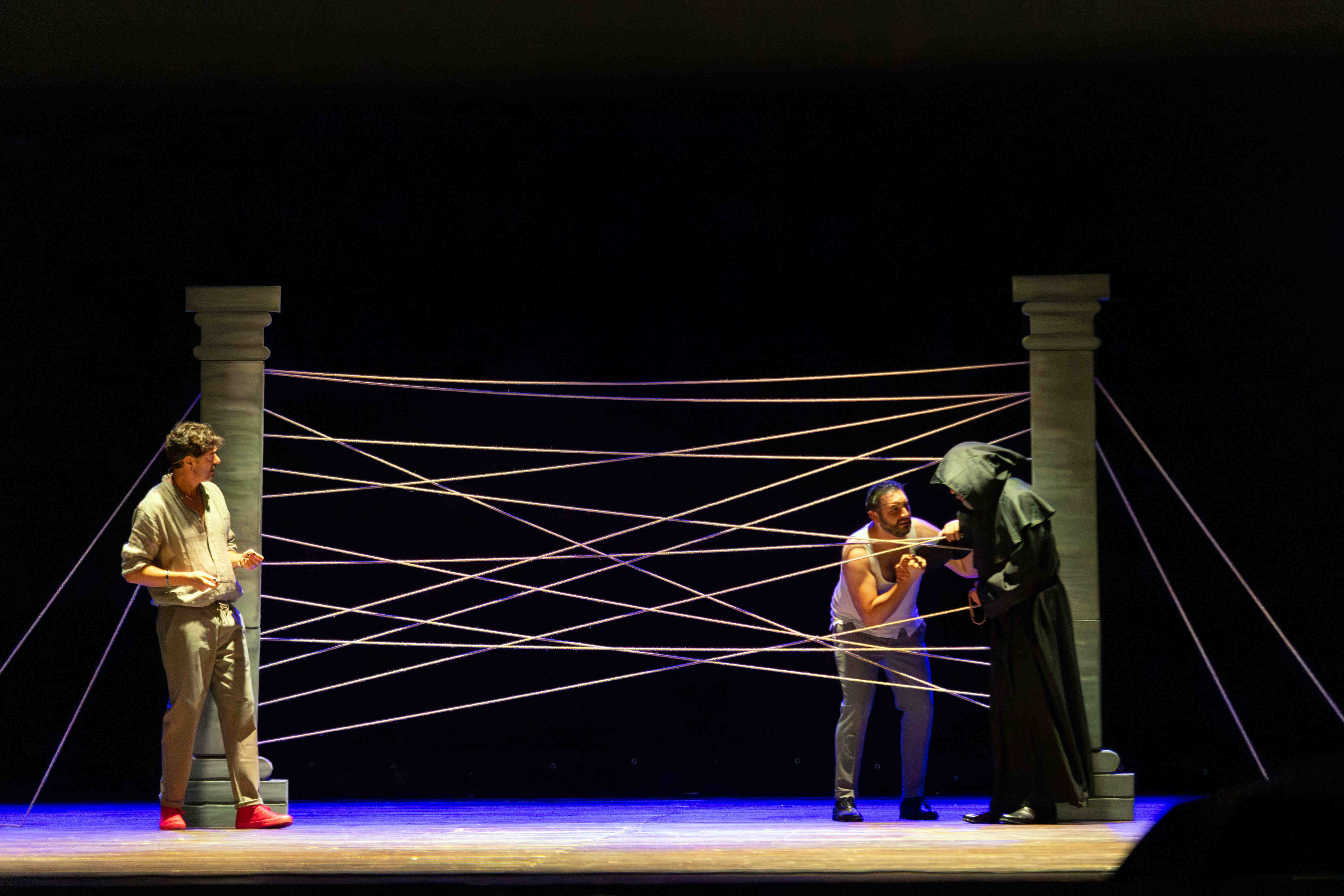 Misura per Misura - Scena con tre attori tra colonne e corde scenografiche