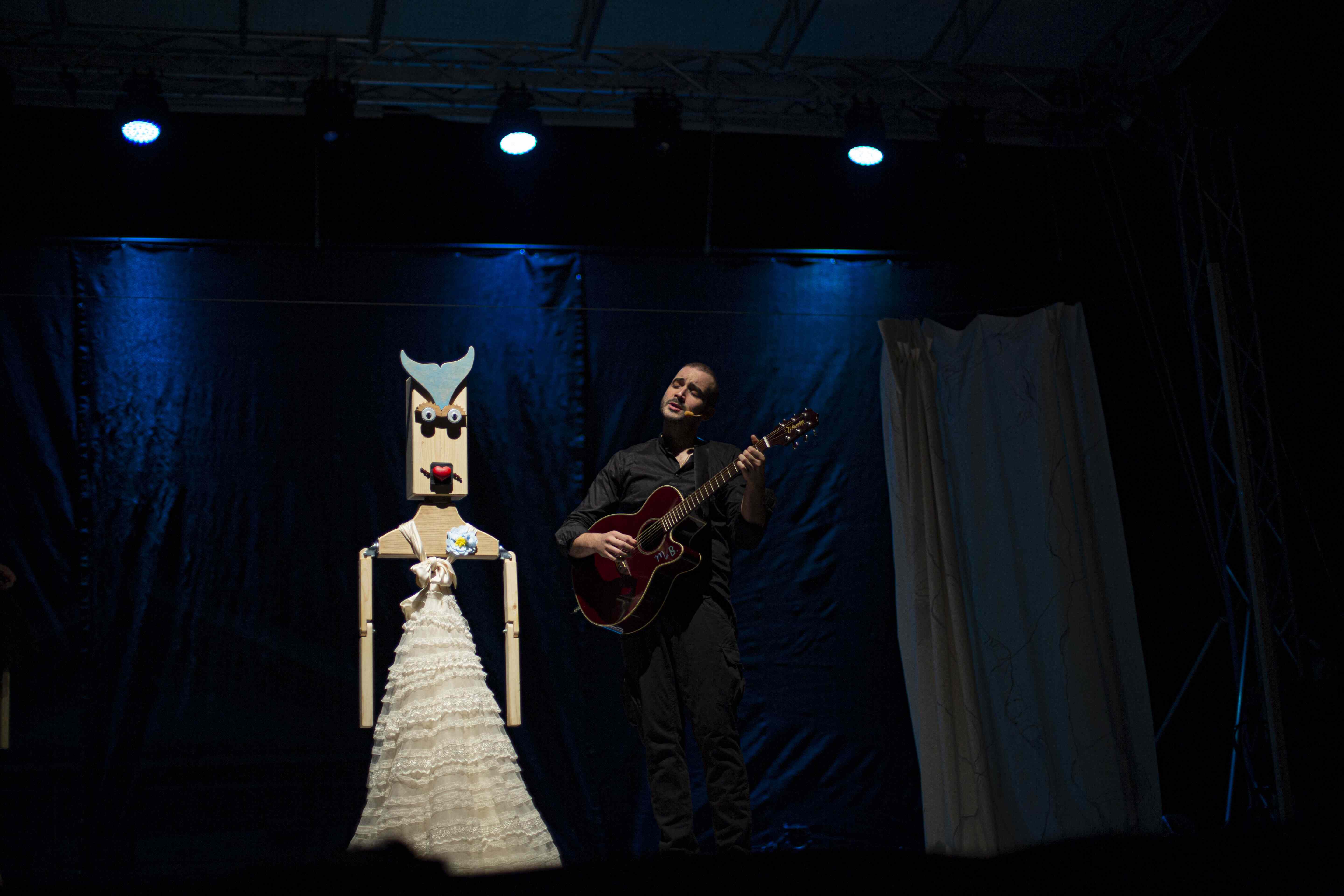 Amleto suona la chitarra accanto a Ofelia in abito da sposa